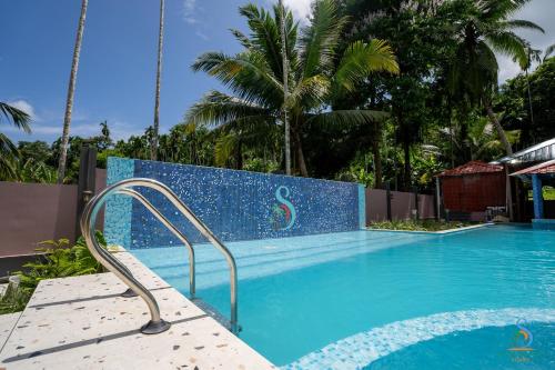 un banc bleu à côté d'une piscine dans l'établissement Senses Havelock resort, à Havelock Island