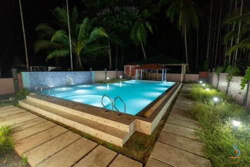 a swimming pool at night with lights around it at Senses Havelock resort in Havelock Island