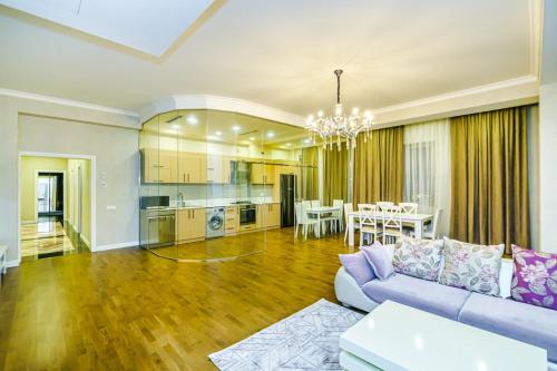 Special VIP Mariott Apartment في باكو: غرفة معيشة مع أريكة وغرفة طعام