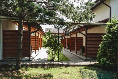 a walkway leading to a building with wooden panels at Sonyachni bungalo in Melʼniki