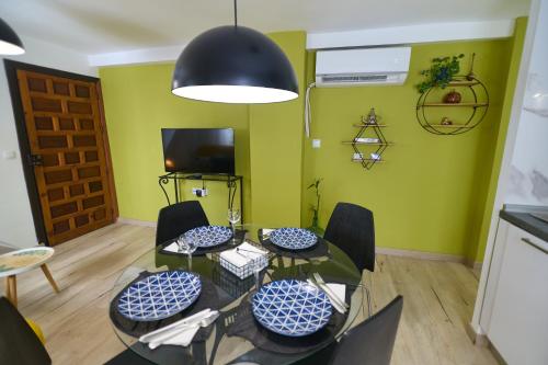 a dining room with green walls and a table and chairs at Casa el "Tablao de las Almendras" in Granada