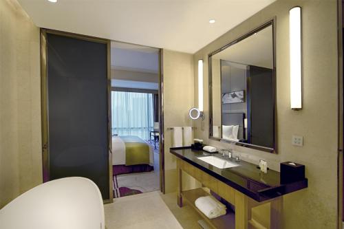 La salle de bains est pourvue d'un lavabo et d'un miroir. dans l'établissement DoubleTree by Hilton Heyuan, à Heyuan