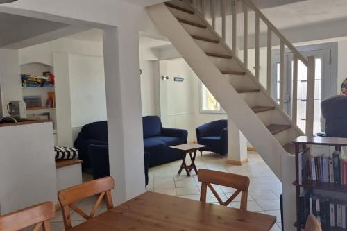 a living room with a staircase and a table and chairs at Plage des Sablettes -St Mandrier Maison du Pécheur in La Seyne-sur-Mer