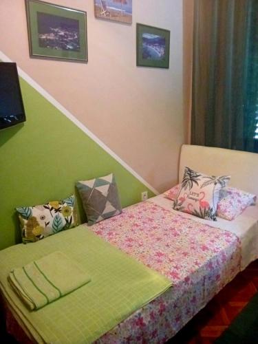 a bedroom with a bed with a green and pink wall at Guest House Cinderella in Herceg-Novi