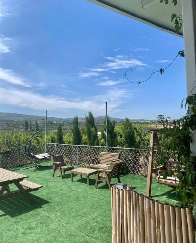 a patio with picnic tables and chairs on the grass at Hamsa Suite in Mas'ade