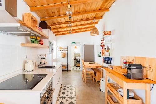 a kitchen with white counters and wooden ceilings at Alqueva Rustic Soul in Alqueva