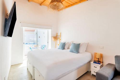 a bedroom with a large white bed and a couch at Alqueva Rustic Soul in Alqueva