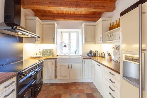 a kitchen with white cabinets and a sink at Das Reet in Middelhagen