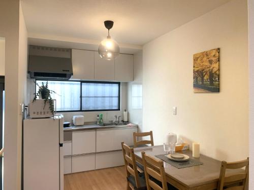 大阪的住宿－Furinkyo・楓林居 5号館，厨房以及带桌子和冰箱的用餐室