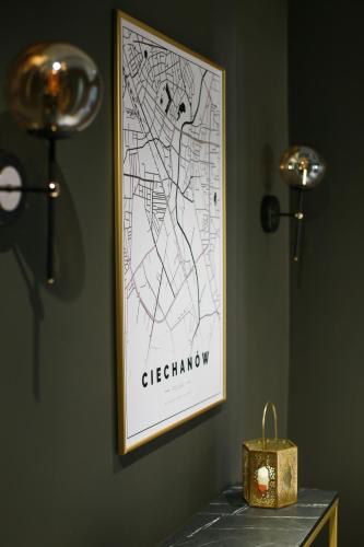 a map on a wall next to a table with a candle at Apartament Cieszynka in Ciechanów