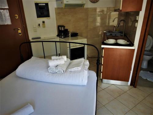 um quarto com uma cama com toalhas e uma cozinha em Konstantinos's Luxury Studio em Tessalônica