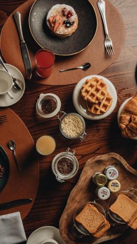 a wooden table topped with plates of food and waffles at Castello di Limatola in Limatola