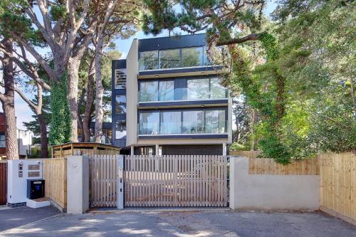 a house with a fence in front of it at Luxury 2 bed 2 bath Apartment in Canford Cliffs