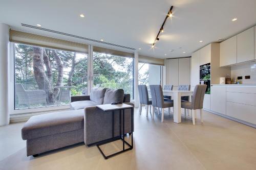 a living room and kitchen with a couch and a table at Luxury 2 bed 2 bath Apartment in Canford Cliffs