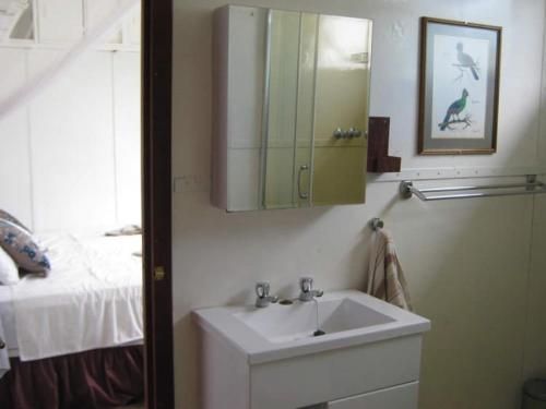 a bathroom with a sink and a mirror and a bed at Houseboat with aircon and splash pool - 2128 in Kariba