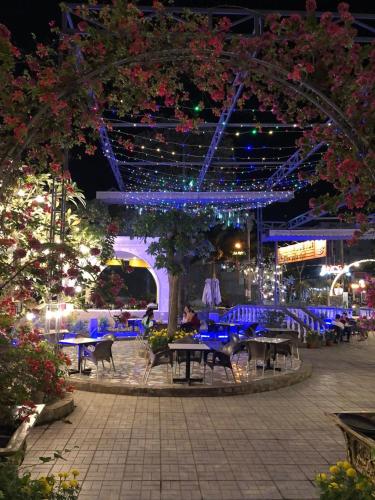 a patio with tables and lights at night at Quê Tôi Hotel in Soc Trang