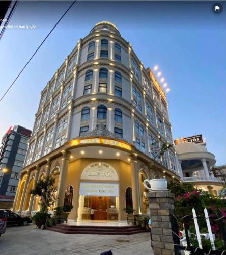 a large white building with a lot of windows at Quê Tôi Hotel in Soc Trang
