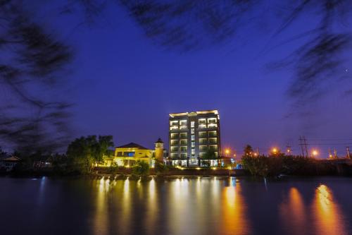 a large building at night on the water at Coco View Hotel in Samut Songkhram