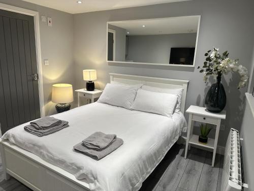 a bedroom with a white bed with towels on it at Beautiful 1-Bed Modern Luxury Apartment in Luton in Luton