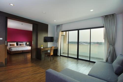 a hotel room with a bed and a desk and a couch at Coco View Hotel in Samut Songkhram