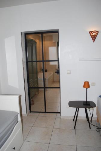 a room with a glass door leading to a bathroom at B&B Coup de Coeur in Moorslede