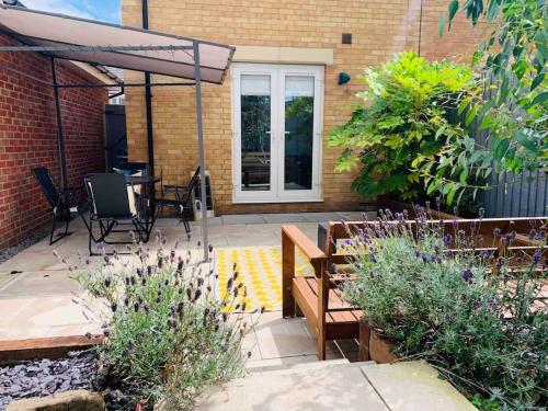 a patio with a table and chairs and an umbrella at Ty Lafant in Abergavenny