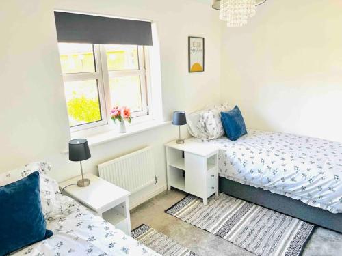 a bedroom with two beds and a window at Ty Lafant in Abergavenny