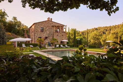 una gran casa de piedra con una piscina frente a ella en Podere la Casina Country Chic, en Rigomagno