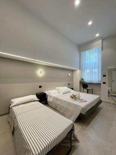 a room with two beds and a window at Civico29 appartamento bilocale in Como