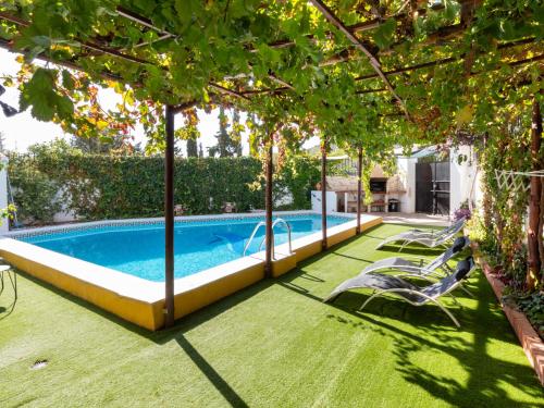 una piscina en un patio con sillas y árboles en Casa samia, en Cónchar