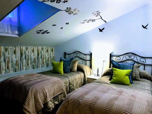 1 dormitorio con 2 camas y techo azul en Pension ILARRAZABAL, en Azpeitia