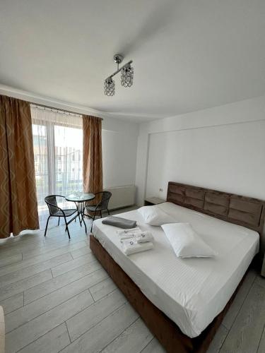 um quarto com uma cama, uma mesa e cadeiras em Luxury by SARAY em Eforie Nord