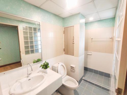 a bathroom with a toilet and a sink at OYO 75446 Travis Inthamara 49 in Bangkok