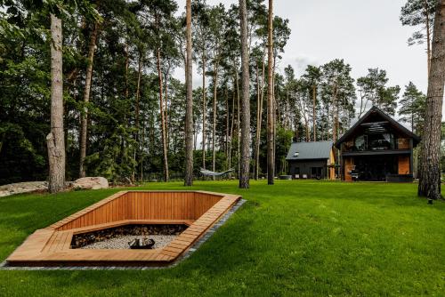 een vuurplaats in het midden van een tuin met een huis bij Rzecznicy Relaksu in Długosiodło