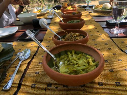 a table with bowls of food on a table at Big Game - Wilpattu by Eco Team in Wilpattu