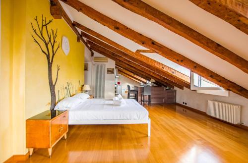 ein Schlafzimmer mit einem Bett und einem Baumbild an der Wand in der Unterkunft Panorama Loft in Triest