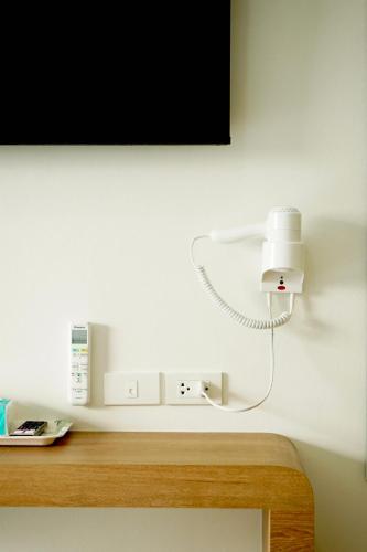 a white light on a wall next to a tv at Mountain&Sea Hotel Prachuap in Prachuap Khiri Khan