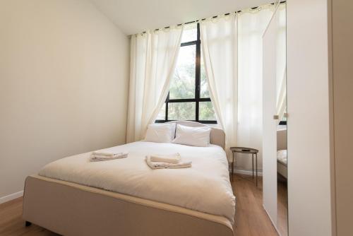 a bedroom with a bed with two towels on it at PORT CITY HAIFA - Authentic German Colony Apartments in Haifa