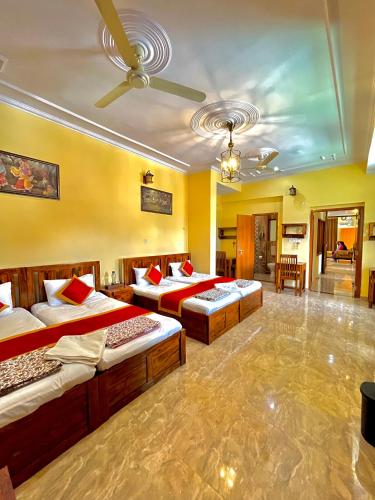 a bedroom with three beds and a ceiling at Beena Homestay in Jaipur