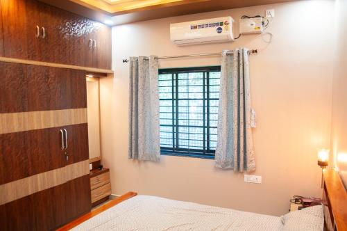 a bedroom with a bed and a window at JFZ Homestay in Honāvar