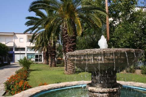 a white cat sitting on top of a fountain at Vicky Rooms & Apartments in Limenas
