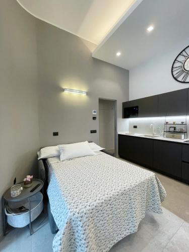 Civico29 appartamento bilocale في كومو: غرفة نوم بسرير وساعة على الحائط