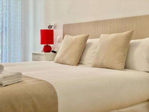 a bedroom with a large white bed with a red lamp at Charming Gran Vía V - Largas Estancias in Madrid