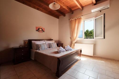 a bedroom with a large bed and a window at Villa Xampelo in Nýmfai