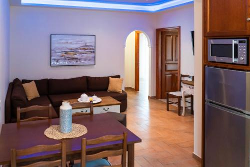 Antheia Apartments في آغيوس ستيفانوس: غرفة معيشة مع أريكة وطاولة