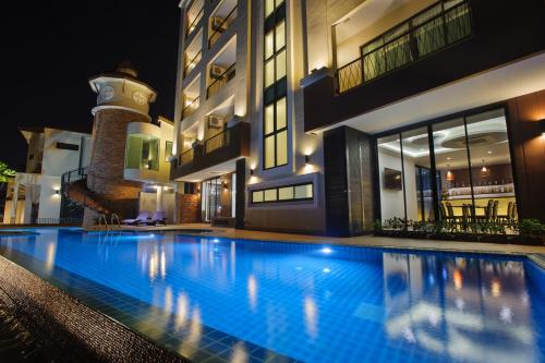 a swimming pool in front of a building at night at Coco View Hotel in Samut Songkhram
