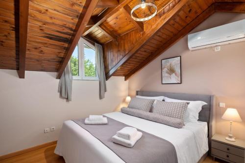 a bedroom with a large bed with wooden ceilings at Peroulades Luxury Villa in Peroulades