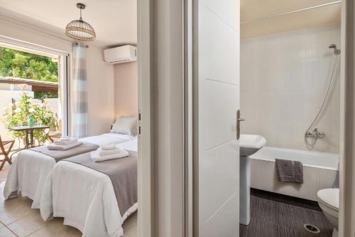 ペロラデスにあるPeroulades Luxury Villaのベッドルーム1室(ベッド1台、バスタブ、シンク付)