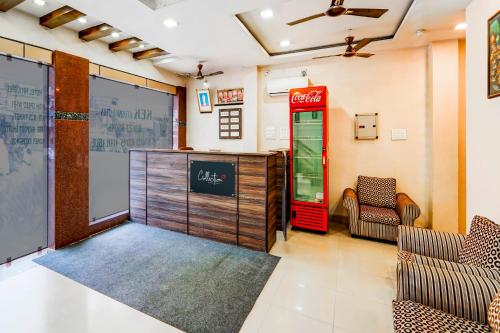 a room with a coca cola machine and chairs at Collection O G Silver Near Airport in Chennai