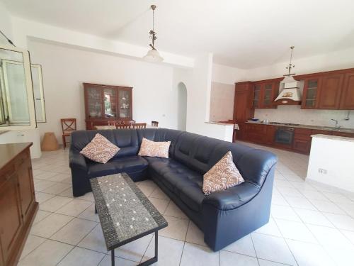 uma sala de estar com um sofá azul e uma cozinha em Casa di Vacanza Marina di Davoli em Marina di Davoli